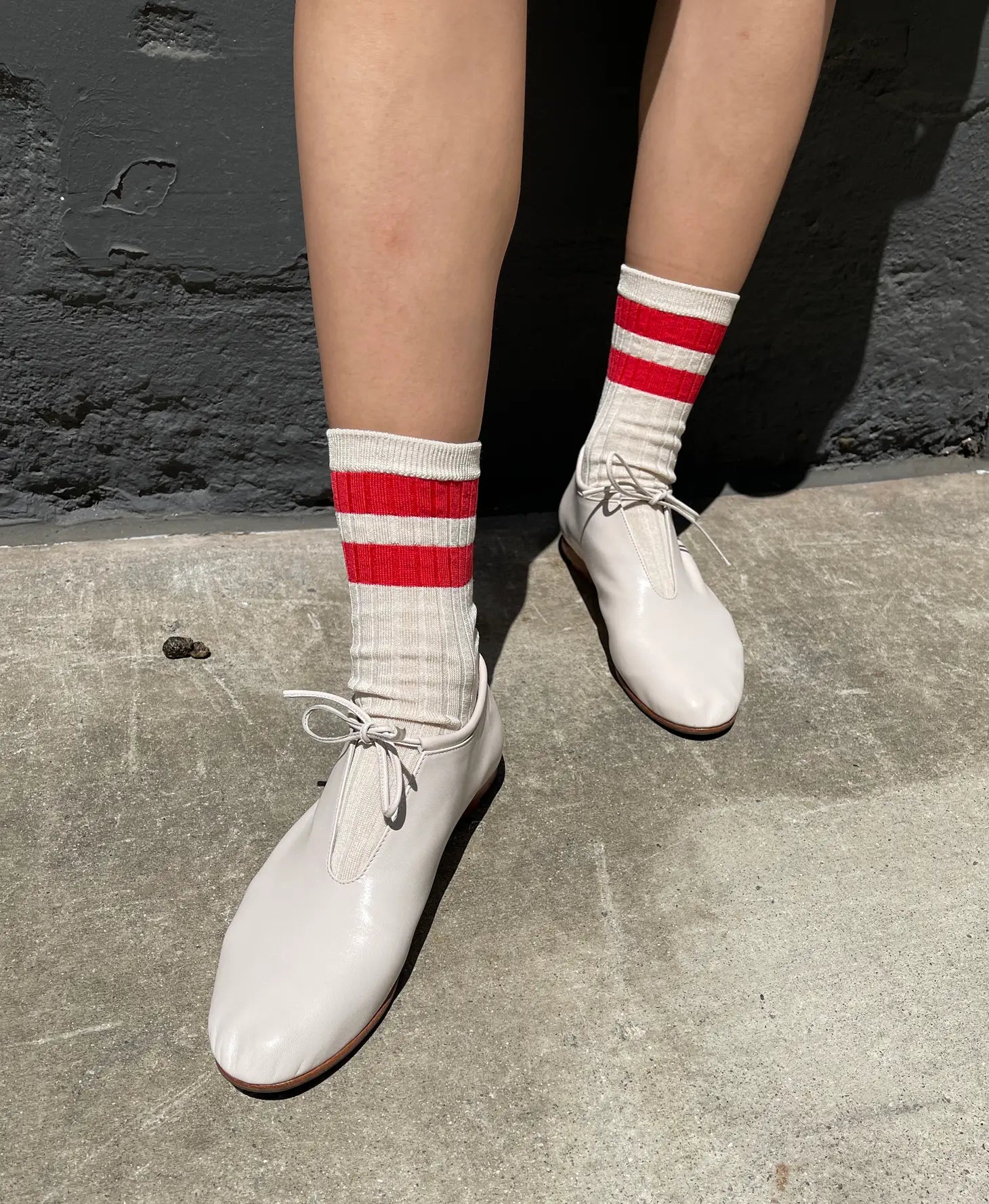 model wearing varsity socks in red and white shoes