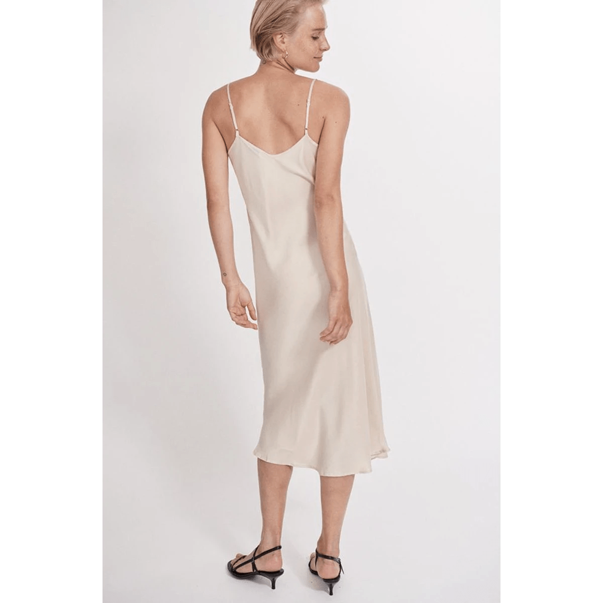 lady wearing cream silk slip dress back