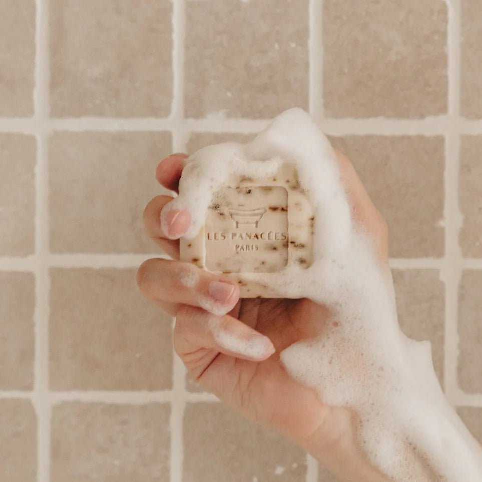 lady holding a Les Panacees soap bar in shower